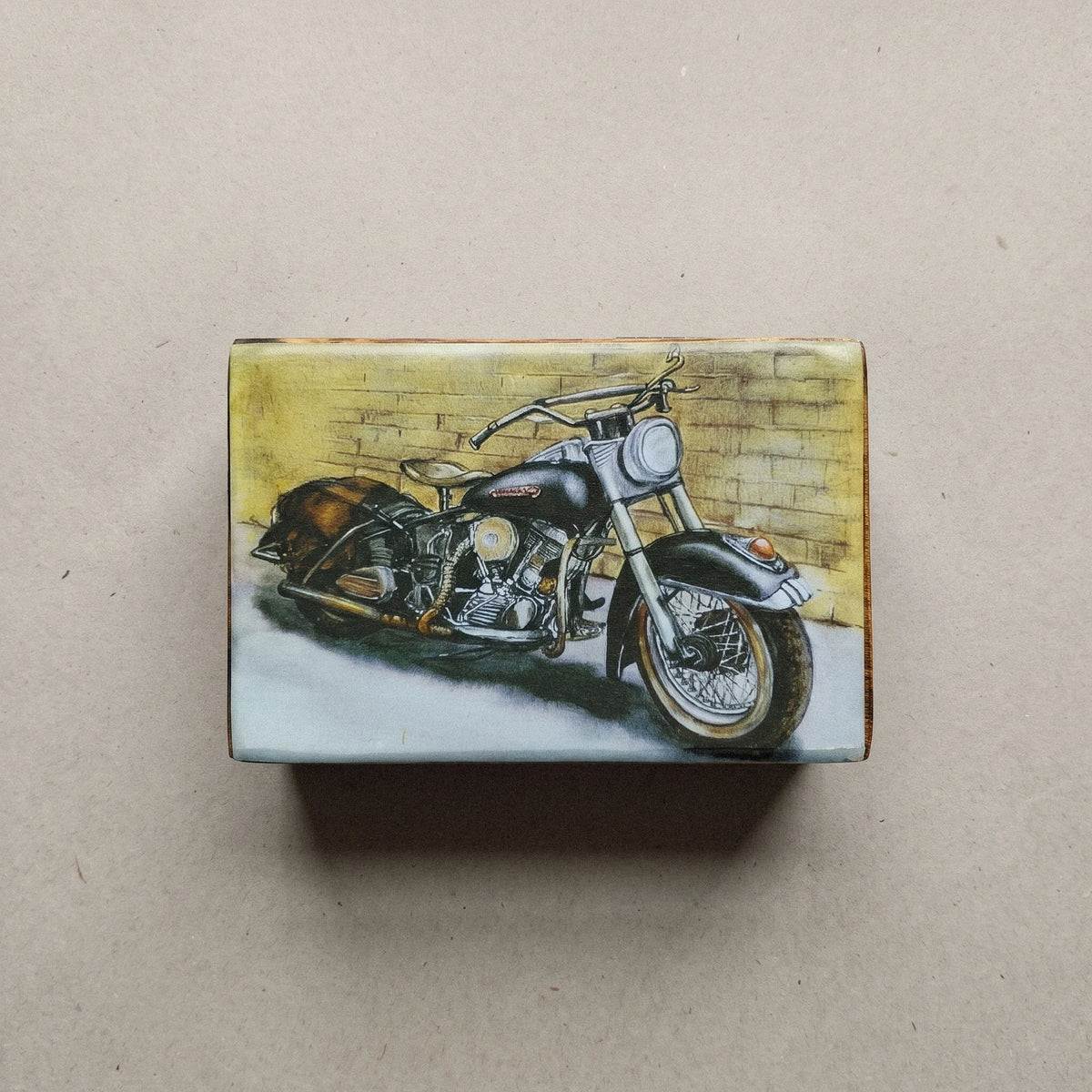 Ξύλινο κουτί από μάνγκο με σχέδιο Harley Davidson φωτογραφημένο από ψηλά, με έμφαση στο σχέδιο του καπακιού.